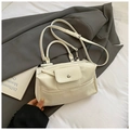 Bolso de mano minimalista blanco roto con asa y correa ajustable sobre un blazer gris - Blanco