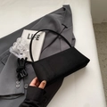 Details der schwarzen Baguette-Tasche mit verstellbarem Schultergurt zum Umhängen - Schwarz