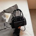 Schicke schwarze Boston-Tasche mit Schleife und Schultergurt auf minimalistischem Hintergrund - Schwarz