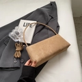 Detail der kamelfarbenen Wildleder-Baguette-Tasche mit abnehmbarem Gurt und urbanem Design - Khaki