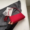 Detail der roten Baguette-Tasche aus Wildleder mit verstellbarem Gurt auf grauem Blazer - Rot