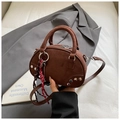 Brown suede Boston bag with silver studs and braided charm on a grey suit jacket - Coffee with Pendant
