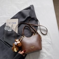 Braune Vintage PU-Leder Handtasche mit Bärenanhänger auf einem grauen Blazer - Braun mit Anhänger