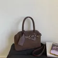Detailed close-up of brown suede and leather tote bag with elegant metallic buckles - Brown
