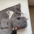 Detail showing grey curly faux fur texture and leather strap of the stylish handbag - Gray