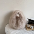 Bolso de piel sintética beige con asa redonda integrada en un entorno acogedor - Beige