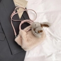 Détail du sac seau en peluche rose avec pendentif lapin sur un fond de tissu texturé - Avec Pendentif (Rose)