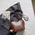 Braune Retro-Umhängetasche aus Leder mit Knotengriffen und Riemen auf grauem Anzug - Braun Ohne Anhänger