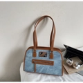 Detalle del bolso de hombro retro de mezclilla y cuero en un entorno de oficina moderno - Azul