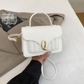 Detailed view of white textured leather handbag with gold U-lock and elegant quilting - White