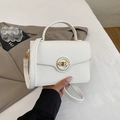Detail of white litchi pattern handbag with a decorative gold round clasp lock - White