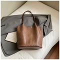 Handwoven dark brown tote bag with slim shoulder strap displayed on a soft grey blazer - Brown No Pendant