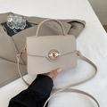 Détail du petit sac carré en cuir beige avec boucle rotative dorée et texture grainée - Kaki