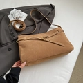 Detail of a brown suede tote bag with vintage gold buckle on a stylish grey suit - Khaki