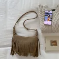 Detailweergave van bruine suède tas met lange franjes op witte getextureerde achtergrond - Khaki
