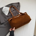 Detailansicht der braunen Wildleder-Beuteltasche mit Ledergriffen und Metallschnalle auf Anzug - Braun