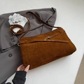 Close-up of deep brown suede hobo bag with vintage gold metal buckle on grey suit - Brown