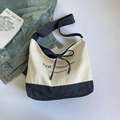 Tragetasche aus Canvas und Denim in Creme und Blau mit Schleife und aufgedrucktem Text - Weiß