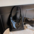 Detail shot of the black leather tote bag with pleated texture used in an office setting - Black