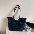 Detalle de bolso tote negro de cuero mate con correa decorativa y hebilla metálica - Negro
