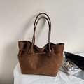 Detalle de bolso tote marrón retro con hebilla decorativa en un escritorio - Marrón