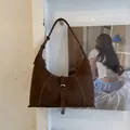 Dettaglio della borsa hobo in pelle testa di moro con cuciture a contrasto e fibbia argento - Marrone