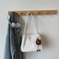 Detalle de bolso bandolera de felpa blanca con colgante de monstruo en percha de madera - Con Colgante / Blanco