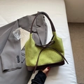 Vue détaillée de la texture du daim vert et des coutures en cuir marron du sac cabas - Vert
