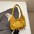 Détail du sac fourre-tout jaune en forme de croissant avec texture daim et petit noeud - Jaune