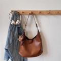 Tragetasche aus karamellbraunem Leder mit Bärenanhänger und Band an einem Haken hängend - Dunkelbraun Mit Anhänger