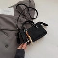 Close-up of black matte square handbag with wood bead charm and zipper detail - Black With Pendant