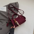 Detail of burgundy suede mini square bag with wooden bead charm on a grey suit jacket - Red with Pendant