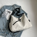 Detalle del bolso bandolera blanco crema con diseño asimétrico y correa ancha negra - Blanco Roto