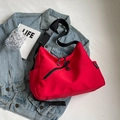 Detalle de bolso hobo rojo sobre chaqueta vaquera con bolsillo con cremallera y correa - Burdeos