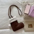 Détail d'un sac chaussette de Noël en daim marron avec garniture sherpa et pompons - Marron