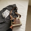 Detail of retro bucket bag with patterned strap, leather trim and bunny charm - Beige Brown With Rabbit Pendant