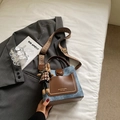 Detail of denim and leather bucket bag with gold rivets and ethnic woven shoulder strap - Blue with Pendant