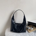 Detail shot of the black crescent tote bag with glossy leather texture and metal zipper - Black