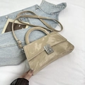 Beige vintage cloud texture handbag with silver twist lock on denim background - Khaki