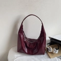 Detail of burgundy half-moon tote bag in oil-wax leather with laptop on white desk - Burgundy