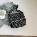 Détail du sac cabas en toile à carreaux avec broderie YES HONEY et veste en jean - Carreaux noir et blanc / Noir