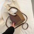 Contrastbruine emmertas met litchi-textuur en modieus lint in een stijlvolle setting - Khaki