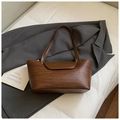 Dettaglio di una borsa tote intrecciata marrone scuro su lenzuola bianche con blazer - Marrone Senza Ciondolo