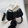 Detail of black glossy shoulder bag with brand logo and adjustable long strap - Black