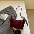 Close-up of burgundy suede underarm bag with black leather strap and silver buckle - Burgundy