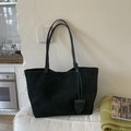 Detalle del bolso tote negro mate con correas delgadas y colgante de cuero decorativo - Negro