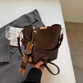 Detailed close-up of brown bucket bag texture with gold metal trim and bunny charm - Coffee (With Pendant)
