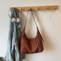 Brown suede tote bag with leather tassels hanging on a wooden wall rack in a lifestyle setting - Brown No Pendant