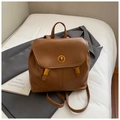 Close-up of caramel vintage leather backpack with golden twist lock and flap design - Brown
