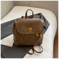 Detailed view of a vintage brown leather backpack featuring a gold metal twist-lock clasp - Khaki
